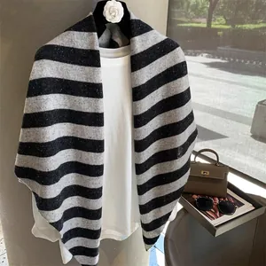 Close-up of black and grey striped knit wool shawl with refined texture and soft drape