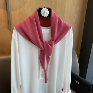 Detailansicht eines rosa gestrickten Wollschals mit Metallschnalle und Textur