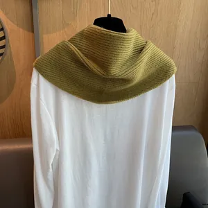 Detail des olivgrünen Strickschals mit dicker Rippenstruktur und geschichtetem Styling
