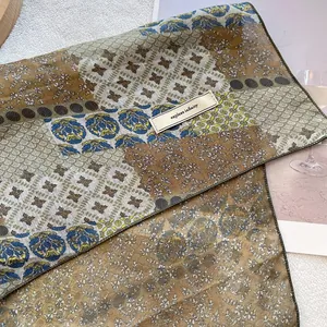 Detail of vintage floral cotton linen scarf featuring explore infinity label and patterns