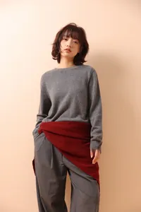 Detail shot of light luxury hollow knit gray scarf draped elegantly over a cashmere sweater