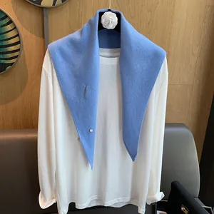 Sky blue knitted wool shawl with vertical texture and button detail over a white top