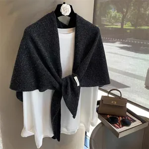 Detail view of 100% pure wool dark grey knit shawl with authentic material label