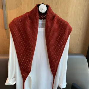 Châle triangulaire en laine ajourée rouge rouille sur un t-shirt blanc décontracté