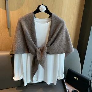Detailed knit texture of coffee brown triangular shawl wrap with knot styling