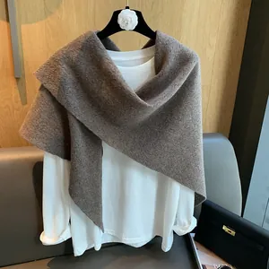Detail of chunky brown knit texture on an elegant triangular shawl and poncho wrap