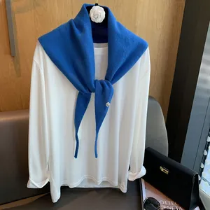 Detailansicht eines königsblauen Strickschals aus Wolle mit weißem Langarmshirt