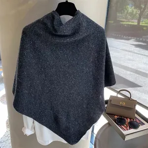Detailed close-up of dark grey wool knit shawl featuring a cozy speckled texture