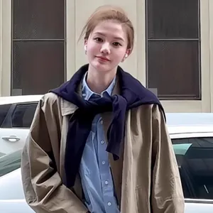 Chic layered look with blue shirt, khaki coat and navy knit shawl over shoulders