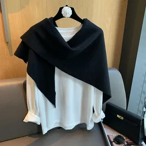 Detail of black hollow knit shawl scarf showing fine texture and asymmetric design