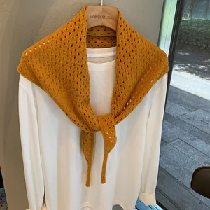 Détail de l'écharpe en laine jaune gingembre montrant le motif de tricot ajouré