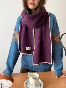Détail macro d'écharpe en laine violette avec bordure contrastée et maille côtelée