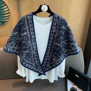Detail of blue and white paisley knit triangle shawl paired with a white shirt
