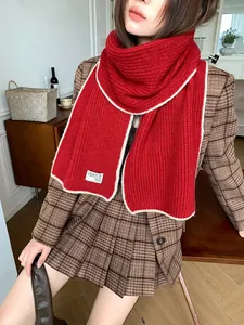 Détail d'une écharpe rouge en laine avec bordure blanche contrastée et texture