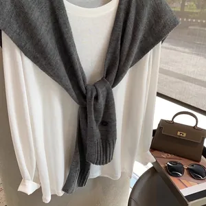 Elegant autumn wool knit shawl worn over a white long-sleeve top for a layered fashion look