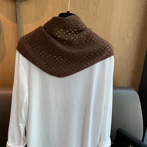Détail du châle triangulaire en laine marron avec motif en tricot ajouré élégant