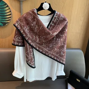 Detail of retro red-brown printed triangle shawl with jacquard ribbon edge on white shirt