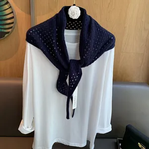 Détail de la texture en tricot et motifs losanges ajourés du châle en laine bleu marine