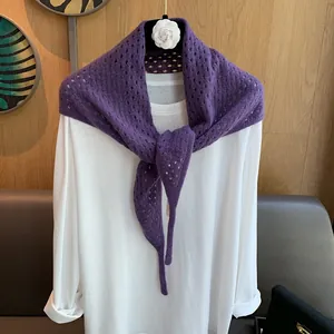 Gros plan sur une écharpe triangle en laine violette avec des détails de tricot ajouré