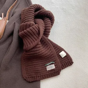 Detail of wool blend knit scarf with exclusive design label and material care tag