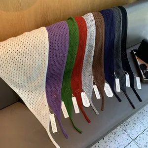 Mise à plat d'écharpes en laine tricotée creuse en neuf couleurs sur un banc