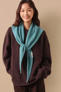 Gros plan sur une écharpe triangle en 100% laine bleu clair avec motif ajouré en arête