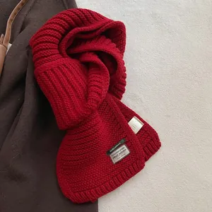 Detail view of red wool blend knit scarf with Baris Living brand label and care tag
