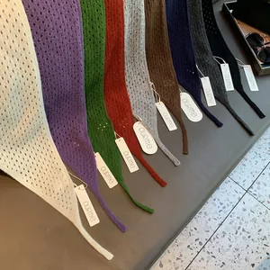 Détails macro d'écharpes en laine tricotée montrant la texture ajourée et divers coloris vifs