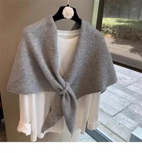 Detail of grey wool blend knitted shawl styled with front knot over a white shirt