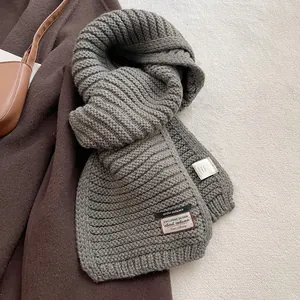 Close-up of thick knit scarf fabric and label showing 15% wool material composition