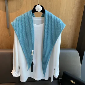 Texture de maille détaillée et étiquette 100% laine sur un châle bleu clair doux