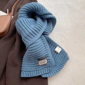 Close-up of winter scarf wool blend fabric with brand label and care tag detail