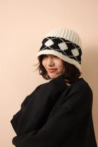 Detailed knit texture of wool bucket hat featuring black and white diamond patterns