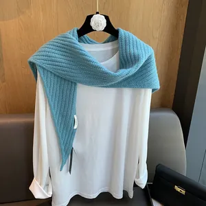 Détail d'un châle en laine bleu lac avec une maille épaisse ajourée à motif arête