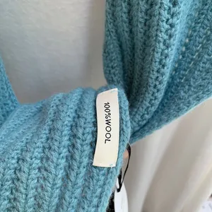 Détail de l'écharpe en pure laine bleu ciel avec une texture de tricot épaisse