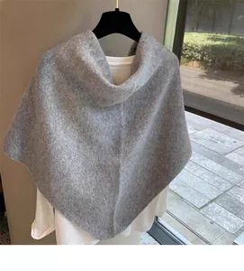 Detailed macro view of the grey wool blend knit texture on the cross scarf wrap shawl