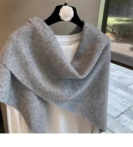 Detail of grey knitted shawl showing soft wool blend texture and elegant cross design