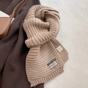 Detail of wool blend scarf showing rib-knit texture and material composition label