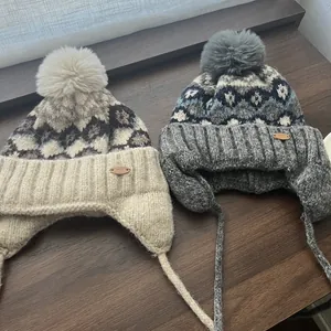 Λεπτομέρεια από πλεκτούς σκούφους Fair Isle με φούντες και γεωμετρικά σχέδια