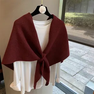 Close-up of wine red knitted shawl with front knot design over a white long sleeve top