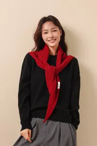 Détail d'une écharpe en laine rouge 100% avec motif chevrons et étiquette en tissu