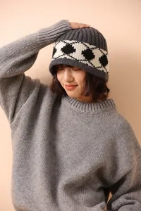 Detailed texture of thick grey wool knit beanie with white argyle pattern for winter