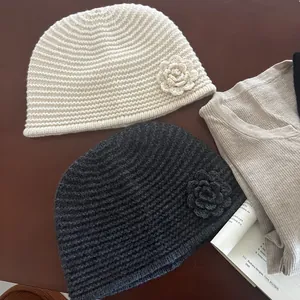 Close-up of handmade crochet flowers and ribbed knit texture on stylish beanies