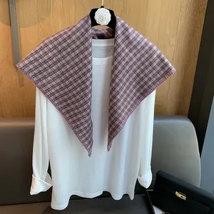 Detail of purple plaid woven shawl featuring thick texture and overlock stitch edges