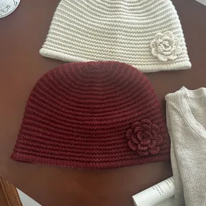 Detail of handmade knit beanie with textured ribs and side floral embellishments