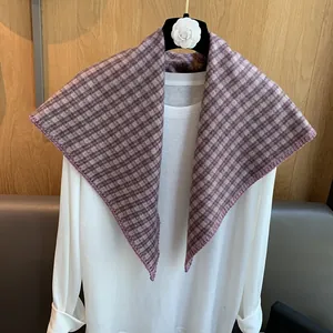 Detail of purple plaid triangular scarf featuring delicate overlock stitching edge texture