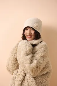 Detailed knit texture of cream-colored floral beanie with 3D crochet flower on the side