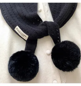 Detail of black knit scarf label showing 92% wool and 8% cashmere blend with pompom