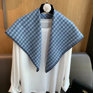 Detail of blue and white plaid knitted shawl with dark handcrafted stitched edges