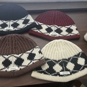 Detailed view of 100% wool material tag on chunky knit beanies with geometric patterns